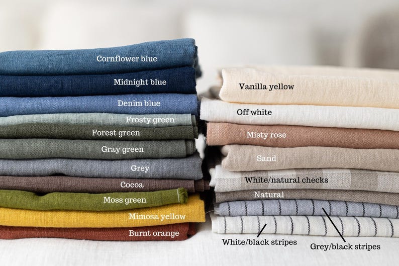 May include: Two stacks of folded fabric swatches in various colors and patterns. Left stack: cornflower blue, midnight blue, denim blue, frosty green, forest green, gray green, gray, cocoa, moss green, mimosa yellow, and burnt orange. Right stack: vanilla yellow, off white, misty rose, sand, white/natural checks, natural, white/black stripes, and grey/black stripes.
