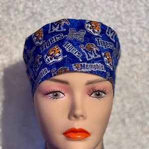 May include: Blue and white surgical scrub hat with a repeating pattern of tigers, the letters "M" and "Tigers", and the words "Memphis Tigers".