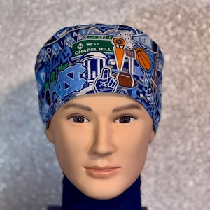 May include: A blue and white patterned scrub cap featuring various graphics, including a basketball, football, and the text "West Chapel Hill". The cap is worn by a mannequin.