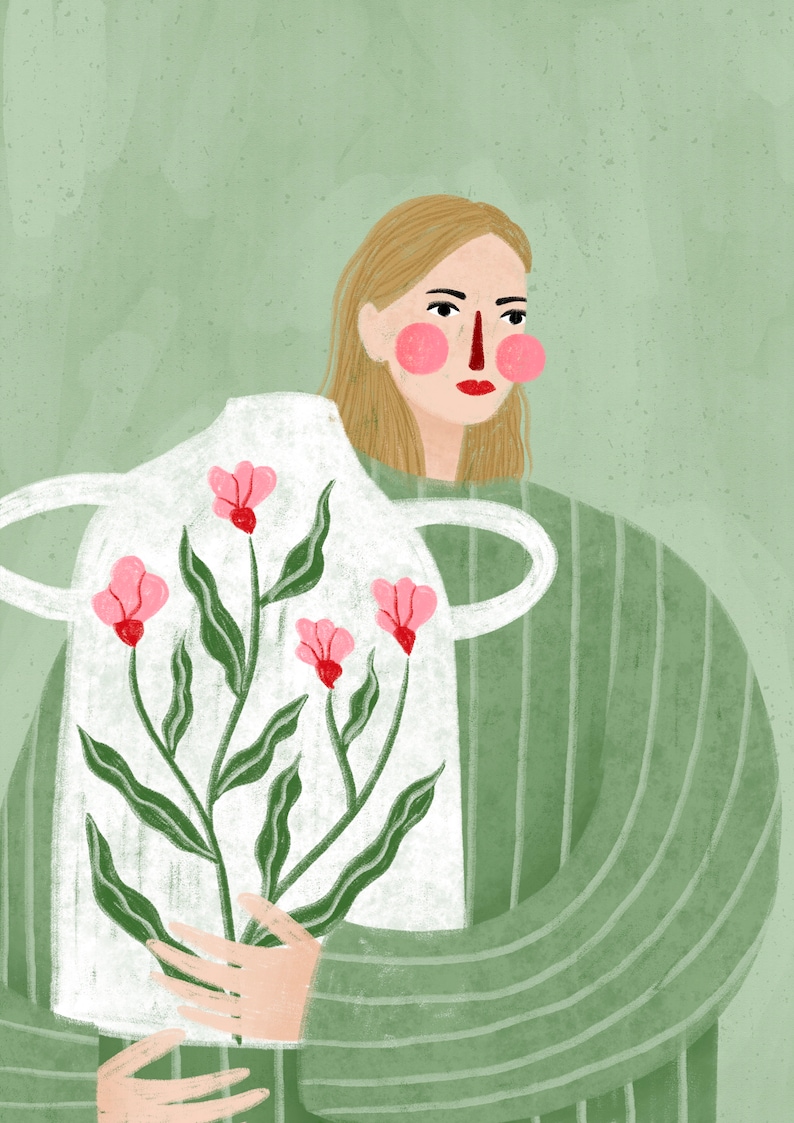 May include: A woman in a green striped shirt holds a white ceramic vase with a floral design. The vase has pink flowers and green leaves.
