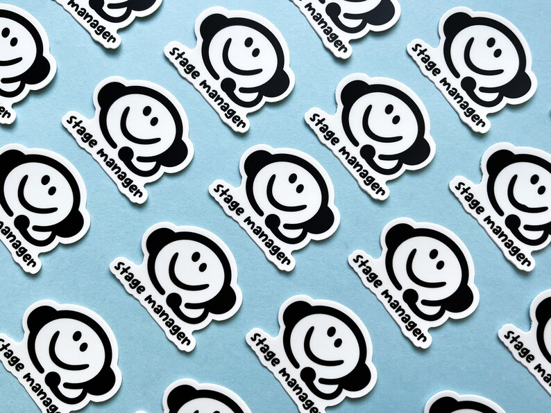 May include: Multiple black and white stickers with a smiling face and the text "stage manager" on a light blue background.