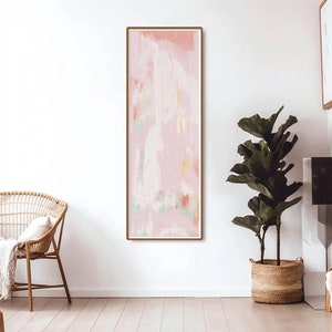 Könnte beinhalten: Abstrakter Kunstdruck in einem Farbschema aus Hellrosa, Pfirsich und Grün. Der Druck ist in einem dünnen, hellbraunen Rahmen gerahmt.