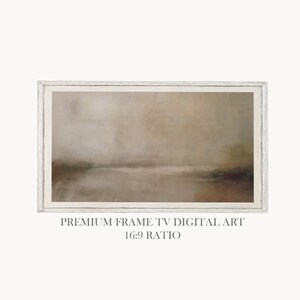 May include: A framed digital art print with a landscape scene in muted tones of brown, beige, and gray. The artwork is rectangular with a 16:9 ratio and is labeled "PREMIUM FRAME TV DIGITAL ART". The frame is white.