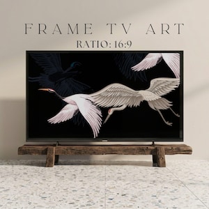 May include: A black framed TV displaying a digital art print of white cranes with outstretched wings against a black background. The TV is mounted on a rustic wooden stand. Text at the top reads "FRAME TV ART" and "RATIO: 16:9".