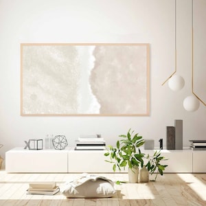 May include: A framed abstract painting with a light beige and white color scheme hangs on a white wall above a white entertainment center. The painting features a soft, watercolor-like effect with a subtle wave pattern.