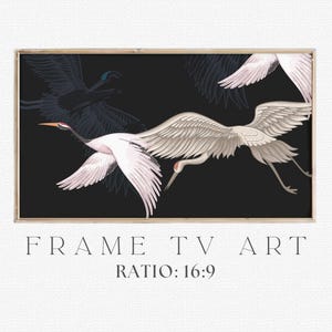 May include: A framed print featuring three white cranes in flight against a black background. The birds have outstretched wings and long legs, with red accents on their heads and beaks. The text "FRAME TV ART" and "RATIO: 16:9" are displayed below the image.