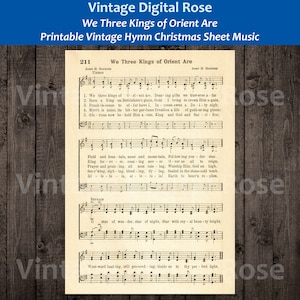 May include: Vintage sheet music for the Christmas carol "We Three Kings of Orient Are". The sheet music is printed on aged paper with a brown background. The music notes are black and the lyrics are in black text. The title of the song is printed in bold black text at the top of the page.