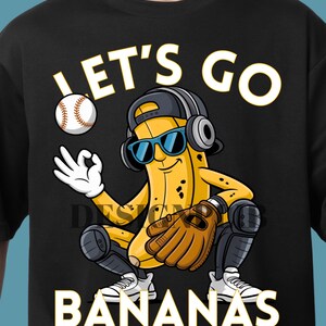 Peut inclure: T-shirt noir avec une banane de dessin animé portant des lunettes de soleil, une casquette de baseball et un casque, tenant un gant de baseball et une balle. Le texte "LET'S GO BANANAS" est en blanc.