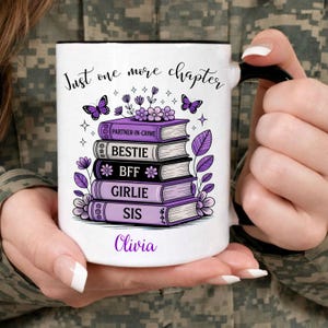 Peut inclure: Une tasse en céramique blanche avec une anse noire et le texte "But First, Coffee" dans un style manuscrit. La tasse est posée sur une surface blanche. La tasse mesure environ 10 cm de haut.