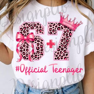 May include: White t-shirt with a pink and black leopard print design. The design includes the numbers 67, a pink bow, a plus sign, a pink crown, and the text "#Official Teenager" in pink script.