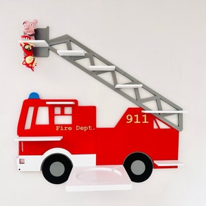Könnte beinhalten: Rotes und weißes Feuerwehrwagen-Wandregal aus Holz mit einer grauen Leiter und Regalen. Der Wagen trägt die Aufschriften "Fire Dept." und "911".