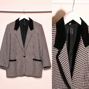 Op de afbeelding: Een zwart-wit geblokt blazer met een zwarte fluwelen kraag. De blazer heeft een enkele knoopsluiting en twee zakken.