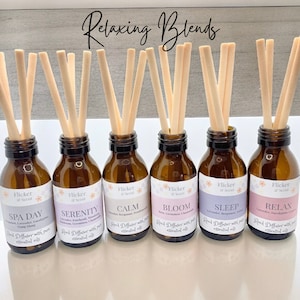 May include: Six brown glass bottles with reed diffusers and labels that say "Flicker & Scent" and different scents: "Spa Day", "Serenity", "Calm", "Bloom", "Sleep", and "Relax".