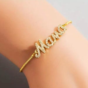 Pulsera bañada en oro “Mamá” – Elegante pulsera con letras de cristal para mamás, regalo con bolsa tejida a mano