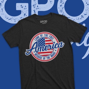 May include: A dark grey t-shirt with a vintage-style circular graphic featuring an American flag and the text "Land of the Free, America, Because of the Brave".