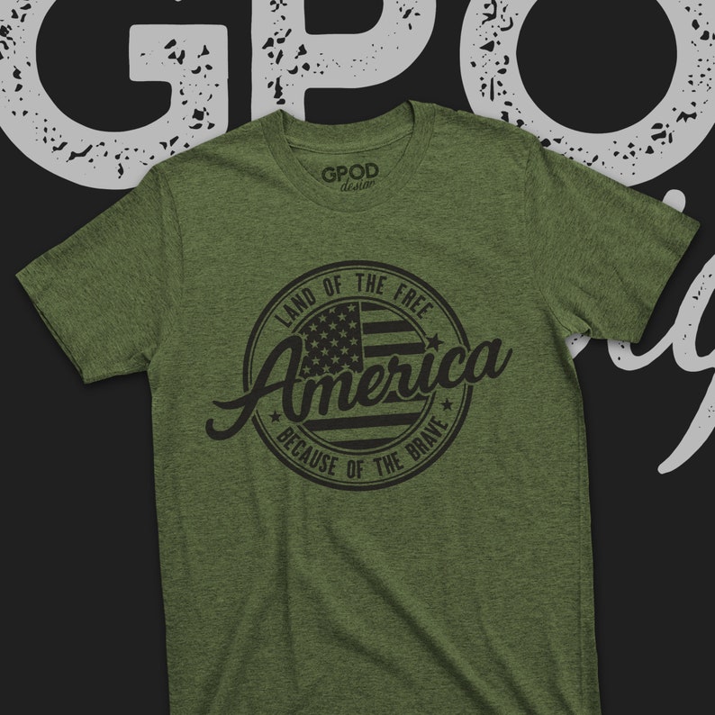 May include: A green t-shirt with a black circle design featuring an American flag and the text "Land of the Free, America, Because of the Brave".