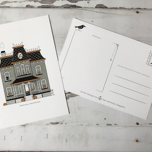 May include: A black and white illustration of a spooky house with a black cat on the porch. The house has a grey exterior with black trim and a black roof. There are orange pumpkins on the porch and in the yard. The house is located in Fairvale, California. The postcard is designed by The Sketchy Pumpkin.