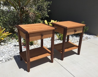 May include: Two wooden end tables with a drawer and a shelf. The tables are made of cherry and walnut wood and have a natural finish.
