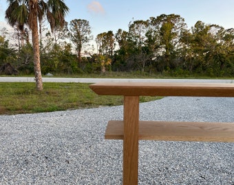 Könnte beinhalten: Ein Konsolentisch aus Holz mit natürlicher Oberfläche und zwei Ablagen. Der Tisch ist aus massivem Holz gefertigt und hat ein schlichtes, modernes Design.