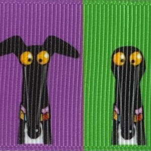 Op de afbeelding: Een kleurrijk lint met cartoon windhond gezichten. Elke hond, met zijn grote gele ogen, staat tegen een andere gekleurde achtergrond: blauw, oranje, rood, paars, groen, geel en blauw. De honden hebben zwarte lichamen en lange snuiten.