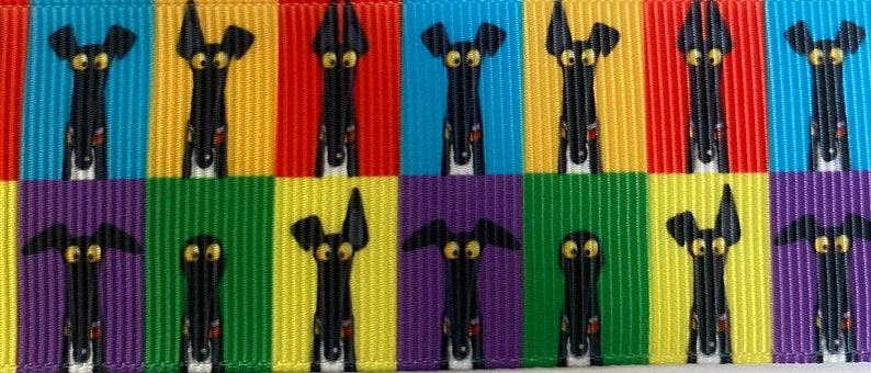 Op de afbeelding: Een kleurrijk lint met een herhaald patroon van cartoon windhonden. Elke hond heeft een zwart lichaam, een witte borst en grote gele ogen. De achtergrond wisselt af tussen rode, gele, groene, blauwe, paarse en turquoise verticale strepen.