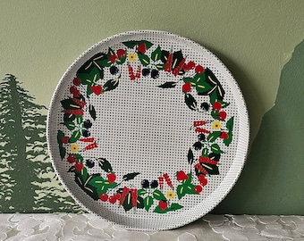 May include: White round serving tray with a green, red, and black floral design. The tray has a woven pattern.