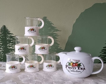 May include: A set of six white ceramic teacups and a white ceramic teapot with a fruit design and the text "Fruit Tea Collection".