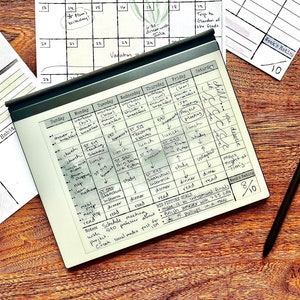 May include: A black and white weekly planner with handwritten notes and a schedule for the week. The planner is on a wooden surface with a black stylus next to it. The planner has a book rating section with a score of 8 out of 10.