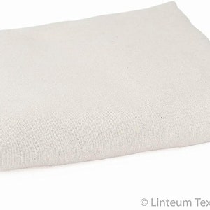 May include: A white cotton drop cloth, folded in half, is a versatile tool for protecting surfaces during painting, staining, or other messy projects.