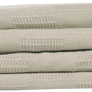 May include: A folded beige throw blanket with a textured weave.