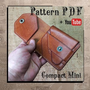 May include: A brown leather wallet with a snap closure, held open to display the interior. The wallet is labelled "Compact Mini" and "Pattern PDF + YouTube". The leather has visible stitching and a textured appearance.
