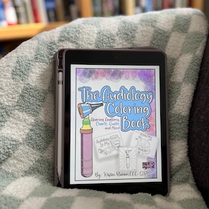 以下が含まれることがあります： 「The Audiology Coloring Book」というタイトルの塗り絵の表紙が表示されたデジタルタブレット。表紙には、聴診器、補聴器の入った瓶、脳の図など、カラフルなイラストが描かれている。「Hearing Anatomy, Charts, Quotes, and More!」というテキストも表紙に含まれている。この本は、Kristen Rumen, CCC-SLPによるものである。