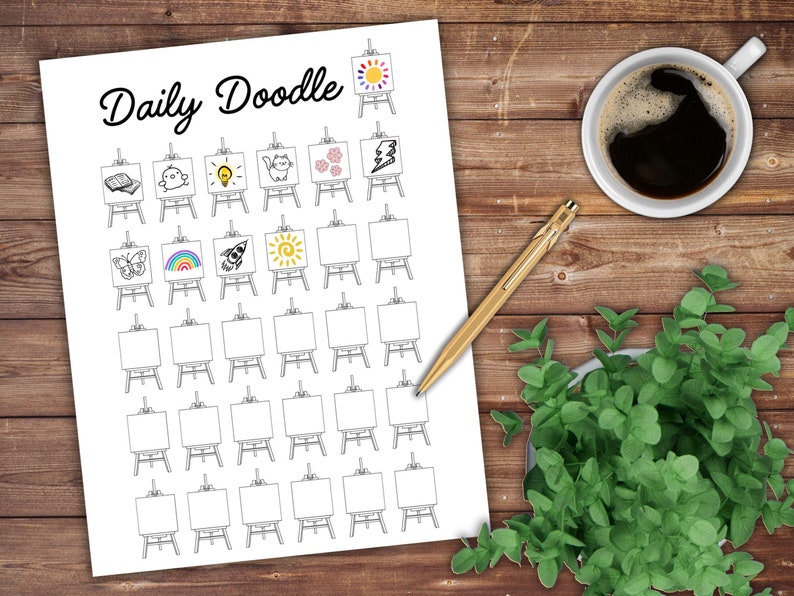 May include: A white paper with the words "Daily Doodle" in black script. The paper features a grid of small easels, each with a different doodle, including a book, a lightbulb, a cat, flowers, a lightning bolt, a butterfly, a rainbow, a rocket, and a sun. A cup of coffee, a gold pen, and a small plant are on a wooden surface.