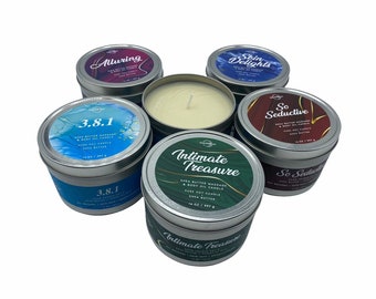May include: Six different scented candles in silver tins with colourful labels. The labels feature text such as "Alluring", "Skin Delights", "So Seductive", and "Intimate Treasure". Each candle is 14 oz (397 g) and is a shea butter massage and body oil candle.