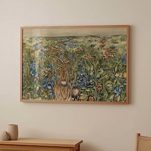 以下が含まれることがあります： 青、オレンジ、緑の色合いの野草のフィールドの額入りプリント。アートワークは、明るい茶色の木製フレームに収められています。プリントは、さまざまな花と葉を描いており、自然で活気のあるシーンを作り出しています。
