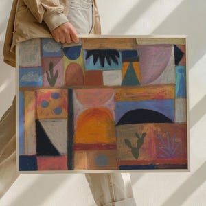 Puede incluir: Obra de arte abstracta en pastel en un marco blanco. La obra presenta un diseño geométrico con varias formas y colores, incluyendo naranja, azul, rosa y marrón. La pieza tiene una apariencia texturizada, lo que sugiere el uso de pasteles o medios similares.