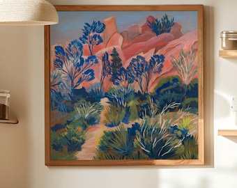 May include: A square framed painting depicting a desert landscape with vibrant pink and orange rock formations, deep blue trees, and green desert shrubs. A light-colored path winds through the center of the scene under a soft blue sky.