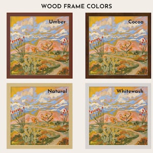 The image is a collage of four different wood frame colors, each containing a framed landscape painting. The paintings depict a desert scene with mountains, cacti, and a winding path. The colors of the frames are Umber, Cocoa, Natural, and Whitewash.