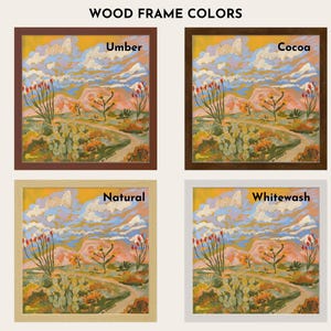 The image is a collage of four different wood frame colors, each containing a framed landscape painting. The paintings depict a desert scene with mountains, cacti, and a winding path. The colors of the frames are Umber, Cocoa, Natural, and Whitewash.