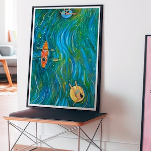 May include: A framed art print featuring an overhead view of a vibrant blue and green river. The painting depicts an orange kayak with two figures, a person floating on a yellow inner tube, and another person on a blue inner tube in the water.