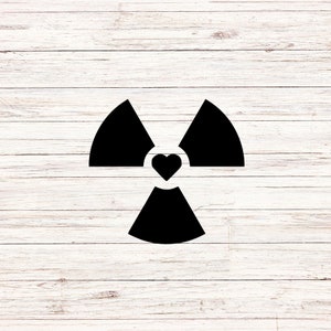 May include: Black and white graphic of a radiation symbol with a heart in the center. The symbol is on a white wood background.