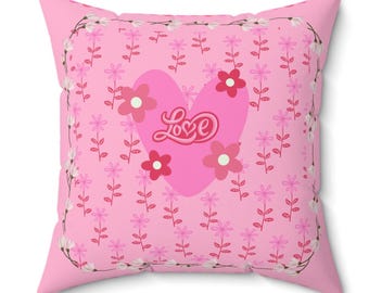 May include: Pink cushion with a pink heart and the word "Love" in a white floral pattern.