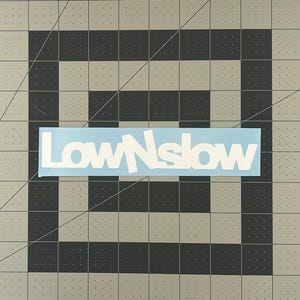 May include: A light blue vinyl sticker with the white text "LowNSlow" in a stylized font.