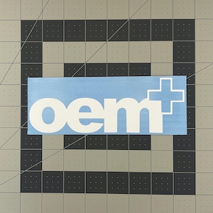 May include: A light blue sticker with white lettering that reads "oem+" in a bold, sans-serif font.
