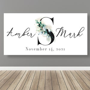 May include: A white canvas print with a black floral design and the text "Amber & Mark" and "November 14, 2021".