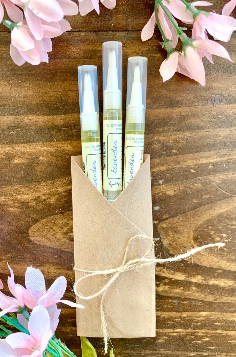 May include: Three small bottles of lavender essential oil packaged in a brown paper envelope tied with twine. The bottles are labeled "lavender essential oil" and have a white cap with a brush applicator.