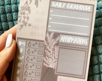 May include: A printable self-care checklist with a brown background and illustrations of plants. The checklist includes sections for daily gratitude, affirmations, and a weekly tracker for water, exercise, and reading.