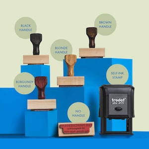 May include: A comparison of different types of rubber stamps. The stamps are arranged in a row from left to right, with the self-inking stamp on the right. The self-inking stamp is black and has the word "trodat" printed on it. The other stamps have wooden handles in various colors, including black, brown, blonde, and burgundy.