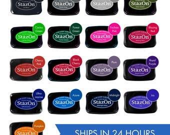May include: A collection of 16 ink pads in various colors, including black, gray, dove gray, olive green, cactus green, forest green, fuchsia pink, blazing red, cherry pink, black cherry, plum, royal purple, ultramarine, azure, midnight blue, and iris. Each ink pad has the words "StazOn" printed on it.