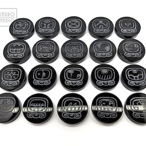 May include: Set of 18 black obsidian stone game pieces with white Mayan glyphs. Each piece features a different glyph.